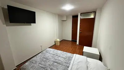 a bedroom with a bed and a flat screen tv at Habitación privada a 20 min del Aeropuerto de LIMA in Lima
