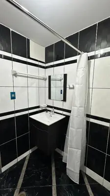 a black and white bathroom with a sink and a mirror at Habitación privada a 20 min del Aeropuerto de LIMA in Lima
