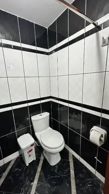 a black and white bathroom with a toilet and a sink at Habitación privada a 20 min del Aeropuerto de LIMA in Lima