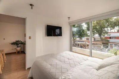 a bedroom with a bed and a large window at Departamento en Barranco in Lima
