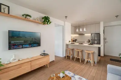 a kitchen and living room with a tv on the wall at Departamento en Barranco in Lima