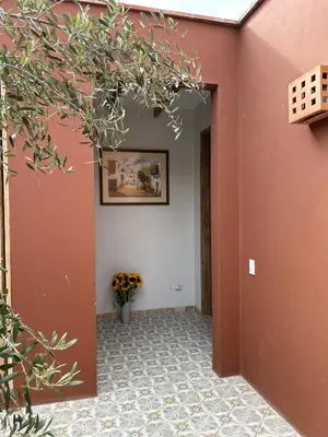a hallway with orange walls and a vase of flowers at Casa de Campo con Piscina, BBQ y Naturaleza Cañete in Imperial