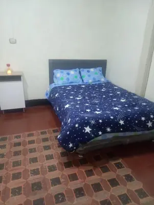 a bed with a blue blanket with stars on it at Habitación Plaza Chosica in Chosica