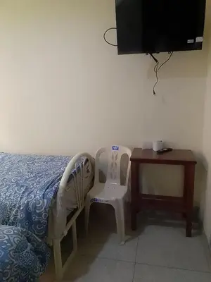 a bedroom with a bed and a table and a tv at Hospedaje TUTUMEME in Churín