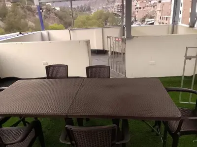 a brown table and chairs on a balcony at Hospedaje TUTUMEME in Churín