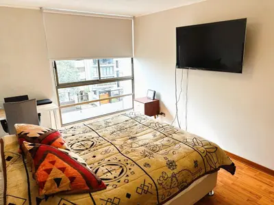 a bedroom with a bed and a flat screen tv at Departamento en Miraflores - Av Pardo Jose in Lima