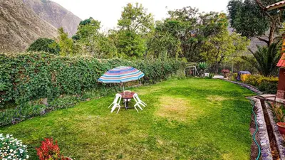 a table and chair with an umbrella in a yard at Casa en Calca in Calca