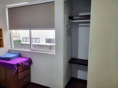 a room with a window and a dresser with a purple sheet at Entire Apartment in Miraflores in Lima