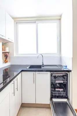 a kitchen with white cabinets and a dishwasher at Intiflatscusco Comfortable Stay in the Heart of the City in Cusco