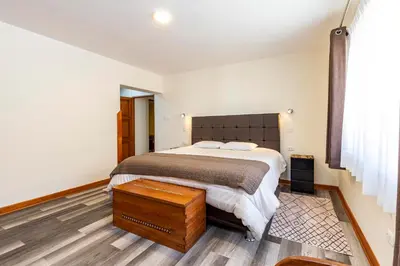 a bedroom with a large bed and a wooden floor at Intiflatscusco Comfortable Stay in the Heart of the City in Cusco