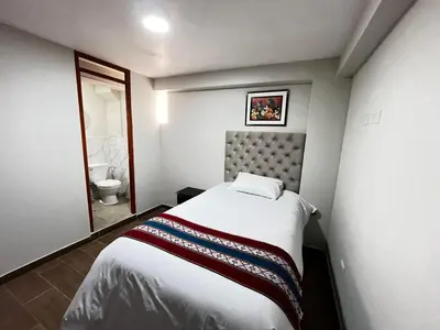 a small bedroom with a bed and a bathroom at Hotel Inka House Chinchero in Chinchero
