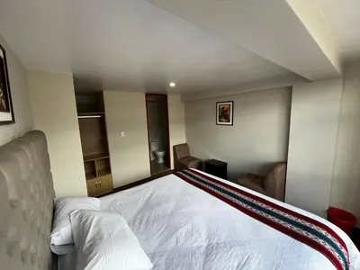 a bedroom with a white bed in a room at Hotel Inka House Chinchero in Chinchero