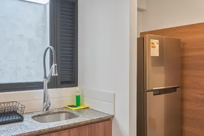 a kitchen with a sink and a window and a refrigerator at Ejército City Lofts & Apartments in Lima