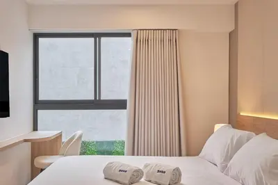 a bedroom with a bed with two towels on it at Ejército City Lofts & Apartments in Lima