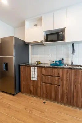 a kitchen with wooden cabinets and a stainless steel refrigerator at Ejército City Lofts & Apartments in Lima