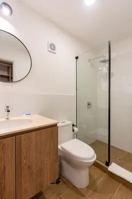 a bathroom with a toilet and a glass shower at Ejército City Lofts & Apartments in Lima