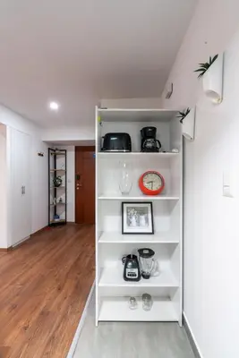 a white book shelf in a living room at Nuvee 2BR by Geko in Lima