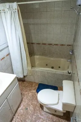 a bathroom with a toilet and a bath tub at Casa en el Medio de todo Estacion tren Angamos in Lima