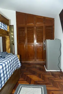 a room with a refrigerator and wooden cabinets at Casa en el Medio de todo Estacion tren Angamos in Lima
