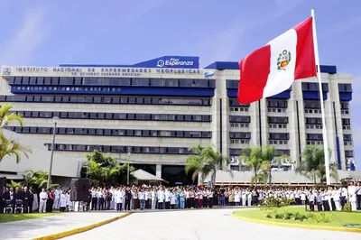 a group of people standing in front of a building with a flag at Casa en el Medio de todo Estacion tren Angamos in Lima