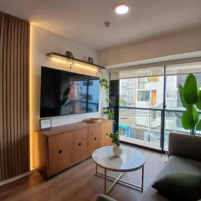 a living room with a large flat screen tv at Vive Barranco, Reserva aquí in Lima