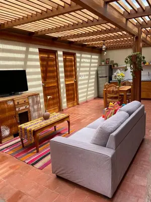 a living room with a gray couch and a television at Charming Urubamba Cusco house - Kapuliyuq in Urubamba