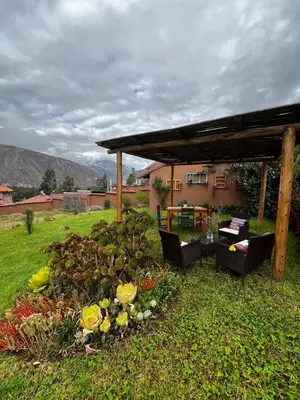a garden with a pavilion and flowers in the grass at Charming Urubamba Cusco house - Kapuliyuq in Urubamba