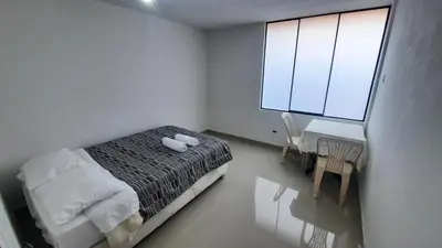 a bedroom with a bed and a desk and a window at HABITACIÓN PRIVADA En Casa a 13 minutos Acceso A Baño, Cocina Y Comedor Compartido in Lima