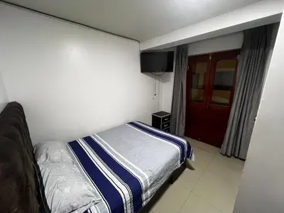a bedroom with a bed and a tv on the wall at Huamanga plaza in Ayacucho