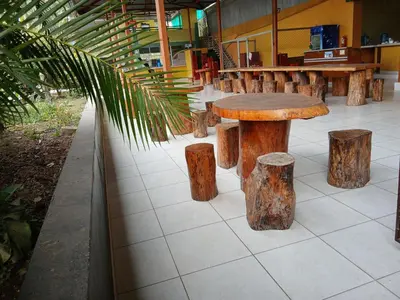 a wooden table and stumps on a tile floor at Recreo Hotel Aldea in Pichanaki