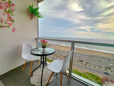 a balcony with a table and chairs and a view of the beach at Exclusivo con vista al mar - Blue Ocean in Lima