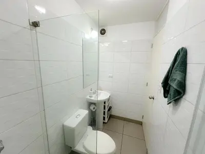 a white bathroom with a toilet and a sink at Exclusivo con vista al mar - Blue Ocean in Lima