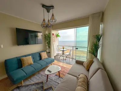a living room with a blue couch and a view of the ocean at Exclusivo con vista al mar - Blue Ocean in Lima