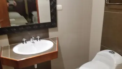 a bathroom with a sink and a toilet and a mirror at Siball Hotel in Abancay