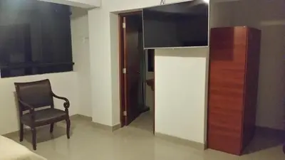 a chair sitting in a room with a mirror at Siball Hotel in Abancay