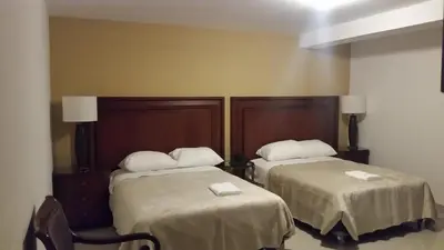 a hotel room with two beds with white pillows at Siball Hotel in Abancay