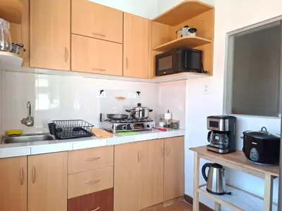 a kitchen with wooden cabinets and a sink at Cusco Hermoso in Cusco