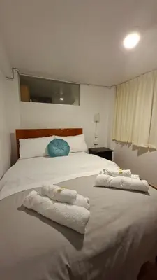 a bedroom with a large white bed with towels on it at Cusco Hermoso in Cusco
