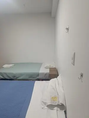 a bed in a room with two lights on it at Departamento Frente al Cc Mega plaza - Ica in Ica