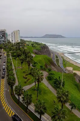 a city with a road and palm trees and the ocean at BSR Oceanview Family Flat w/ Parking in Lima