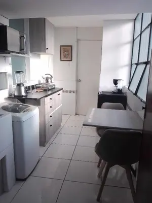a kitchen with white cabinets and a table in it at Miraflores, Lima, mini apartamento 2 ambientes in Lima