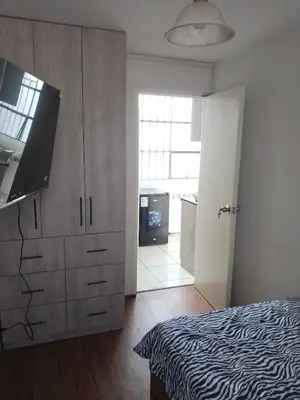 a bedroom with a bed and a dresser with a television at Miraflores, Lima, mini apartamento 2 ambientes in Lima