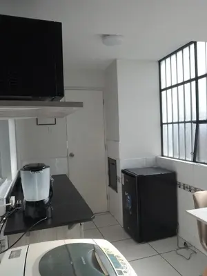 a small kitchen with a sink and a refrigerator at Miraflores, Lima, mini apartamento 2 ambientes in Lima