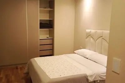 a bedroom with a white bed and a closet at Posada del inka in Cusco