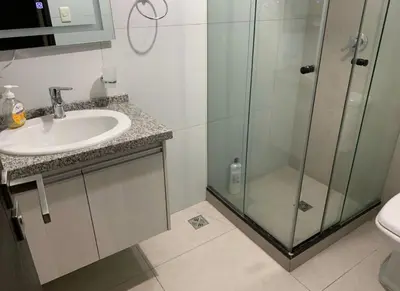 a bathroom with a sink and a glass shower at Los Tambos Apartment in Cusco
