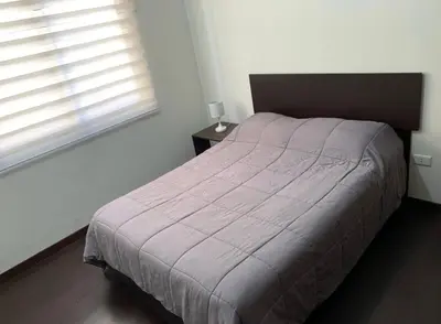 a bedroom with a bed and two windows at Los Tambos Apartment in Cusco
