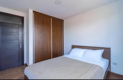 a bedroom with a bed and a wooden door at La Panaca Del Inka Apartment in Cusco