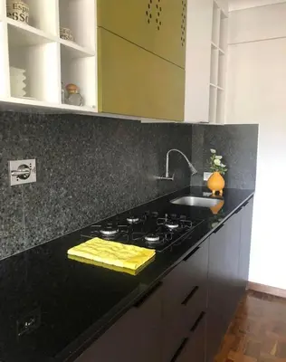 a kitchen with a black counter top with a stove at Inka Garden Apartment Cusco in Cusco