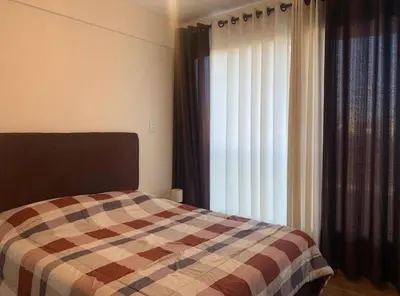 a bedroom with a bed in front of a window at Qori Apartment in Cusco