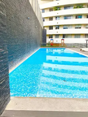 a swimming pool next to a tall building at Apartamento exclusivo a un paso de San Isidro in Lima